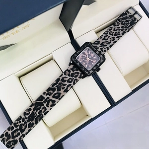 Detailed close-up of a square leopard print watch with golden markers in a cream box