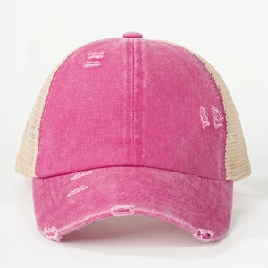 Close-up of distressed rose pink ponytail baseball cap with mesh back and torn details