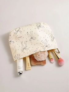 Minimalist beige bow pattern cosmetic bag showing storage capacity with makeup brushes
