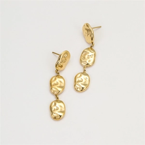 Detailed shot of triple layered gold geometric earrings with a hammered texture finish