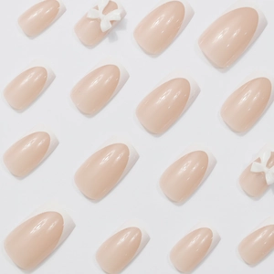 Sweet white French bow press-on nails in nude pink, medium-length almond shape