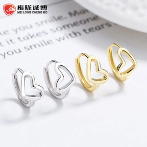 Macro shot of 925 silver and gold heart hoop earrings with detailed minimalist hollow design