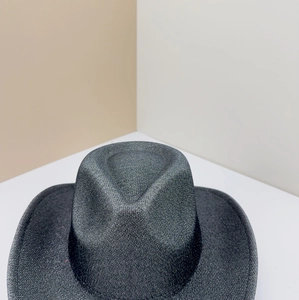 Detail of a dark grey textured western fedora hat featuring a classic indented crown design