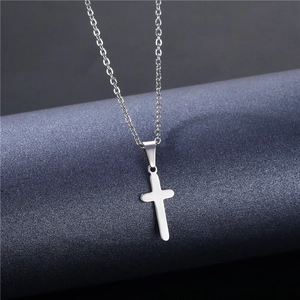 Polished silver stainless steel cross pendant necklace with fine cable chain on display
