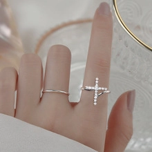 Detail of silver crossover ring with pavé crystals and minimalist silver open band
