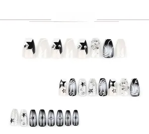Detail view of Y2K style press-on nails featuring star patterns and 3D rhinestone accents