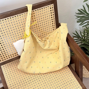 Detail of yellow checkered floral tote bag with colorful dots on a vintage chair