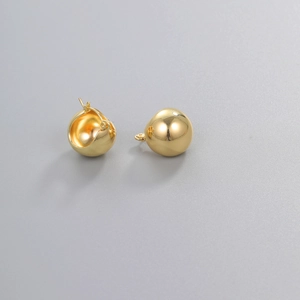 Detail of golden teardrop ball earrings showing latch back closure and hollow structure