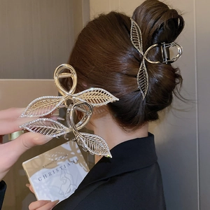 Détail de pinces à cheveux en métal motif feuilles avec strass en doré et argent