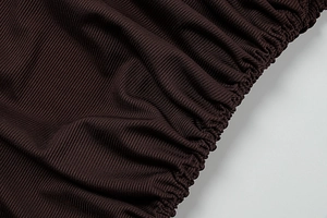 Detail of dark brown ribbed knit fabric with drawstring and elastic ruching texture