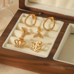 Lot de trois paires de boucles d'oreilles en titane doré avec motifs queue de poisson et couronne