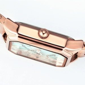 Elegante roségoldene Quarzuhr für Damen mit poliertem Metallgehäuse und geriffelter Krone