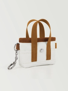 Dettaglio mini portachiavi a borsa in tela con cinturino marrone e gancio argento