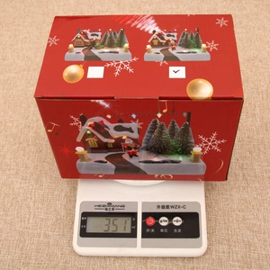 Luminous Christmas music box in gift packaging shown on scale weighing 351g