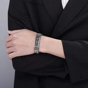 Macro detail of men's vintage titanium steel bracelet with relief totem and metal clasp