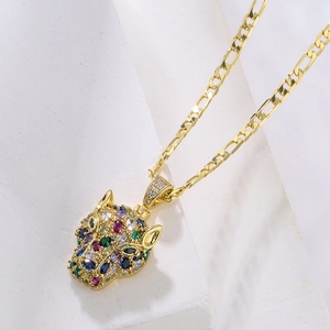 Detail of 18K gold plated leopard pendant with colorful zircons on a Figaro chain