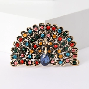 Detailed close-up of a peacock brooch with blue teardrop crystal and colorful rhinestones