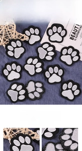 Close-up of paw print embroidery patches showing detailed black and white stitching