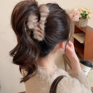 Vue détaillée de la pince à cheveux en peluche rayée avec texture motif tigre et fourrure