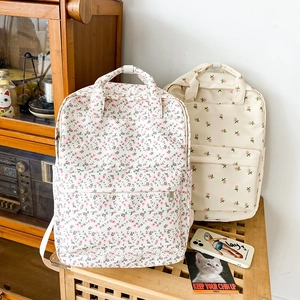 Detailed view of cream floral canvas backpacks in a vintage aesthetic indoor setting