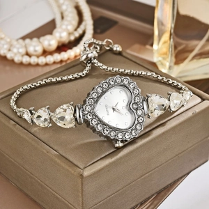 Detail of luxury heart-shaped quartz watch with crystal inlay on a champagne jewelry box