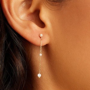 Detail of s925 silver long tassel earrings with pearls and gold chain on model
