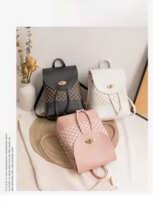 Three mini backpacks in black, white, and pink with circle monogram print and gold locks