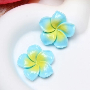 Macro view of blue and yellow gradient resin frangipani charms with glossy finish