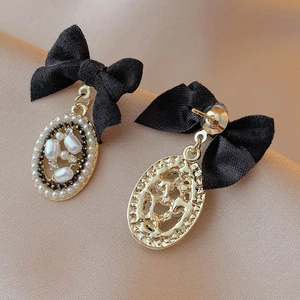 Macro shot of vintage style velvet bow earrings with rhinestones and imitation pearls