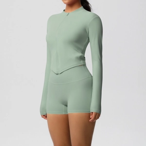 Detail view of sage green two-piece yoga set showing the zipper jacket and v-hem shorts