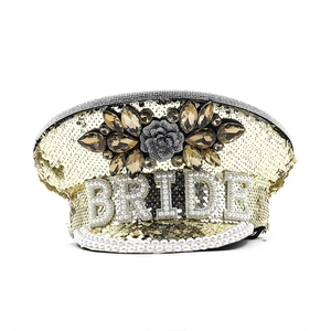 Detail of champagne gold sequined military hat with pearl BRIDE text and gem embellishment