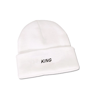 Detail of the white knitted beanie featuring black KING letter embroidery and folded cuff