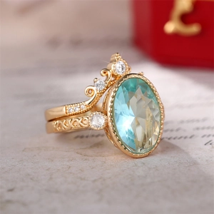 Ensemble de bagues couronne dorées avec grand zircon bleu ovale et motifs gravés
