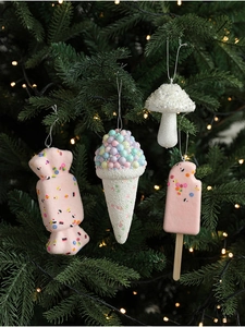 Close-up of pink ice cream and candy Christmas tree ornaments with glitter and beads