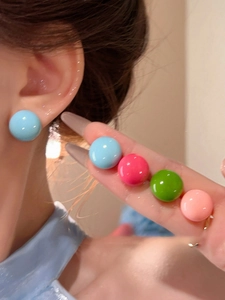 Close-up of vibrant dopamine style colorful round stud earrings for women