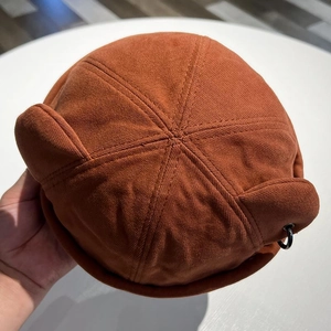Detailed close-up of a brown brimless docker hat with cat ears and a metal ring detail