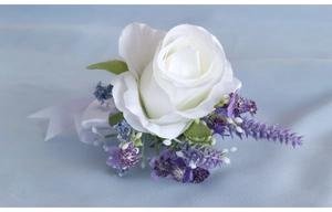 Detail of white artificial rose boutonniere with lavender and white satin ribbon