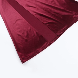 Détail macro de la robe en velours bordeaux montrant la fente et les coutures précises