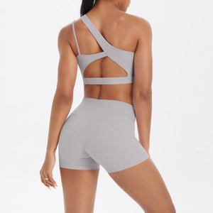 Detail of grey one-shoulder yoga set showing the back cutout bra and high-waist shorts