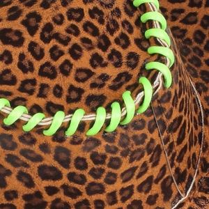 Detail of leopard print cowboy hat featuring neon green hand-woven stitching on the brim