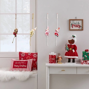 Detail of colorful climbing Santa figurines in red, pink, white, and brown for Christmas decor