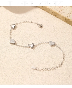 Macro view of S925 sterling silver heart bracelet with polished and crystal charms