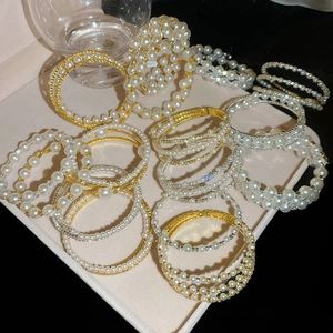 Detail of elegant double-layer pearl and rhinestone bracelets in a pink jewelry box