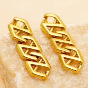 Modern gold geometric earrings with interlocking hollow hexagonal rings on stone