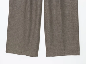 Detailed macro view of high-quality woven fabric texture and hem on brown trousers