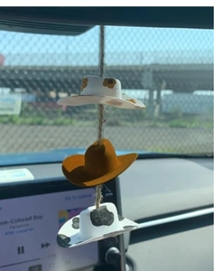 Detail of cute car rearview mirror hanging decor featuring three mini cowboy hats on rope
