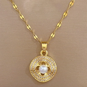 Macro view of gold pendant with double zircon rings and center pearl on velvet
