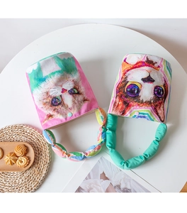 Detail of colorful canvas bucket bags with cartoon cat print and ruffled handles