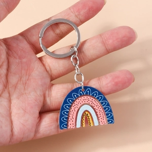 Detail of colorful acrylic rainbow keychain with metal ring held in hand