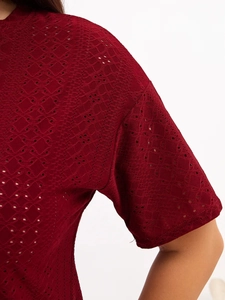 Detailed close-up of burgundy lace hollow-out fabric texture on short sleeve pajama top